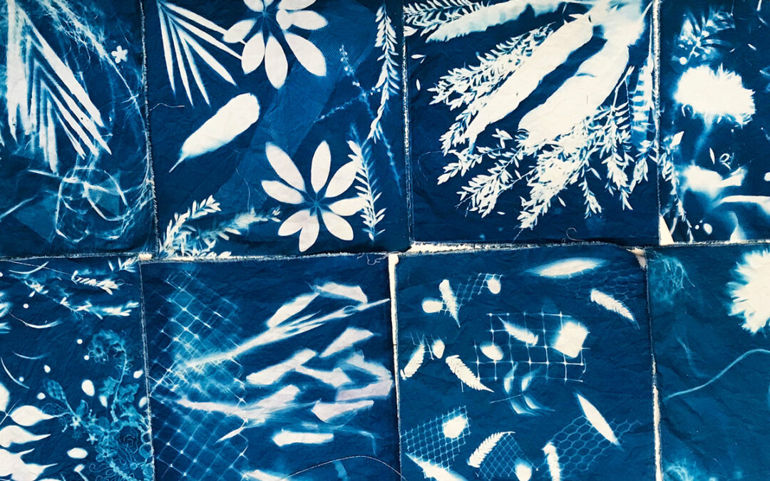 Image of 8 square blue and white prints on cotton. White imprints of mostly plants on blue background.